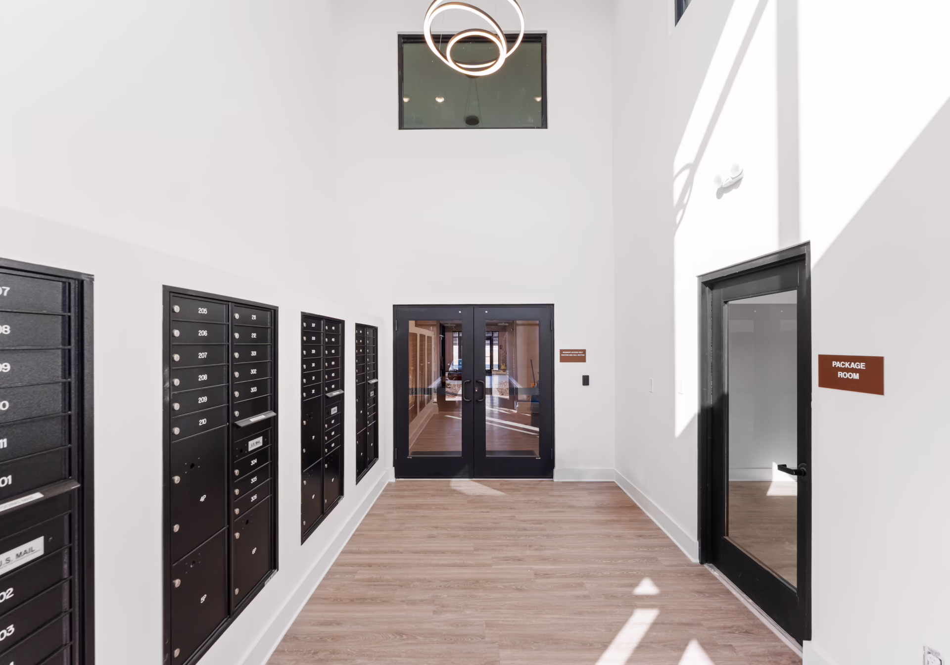 The building lobby, with resident mailboxes along one wall and glazed double doors to the street.
