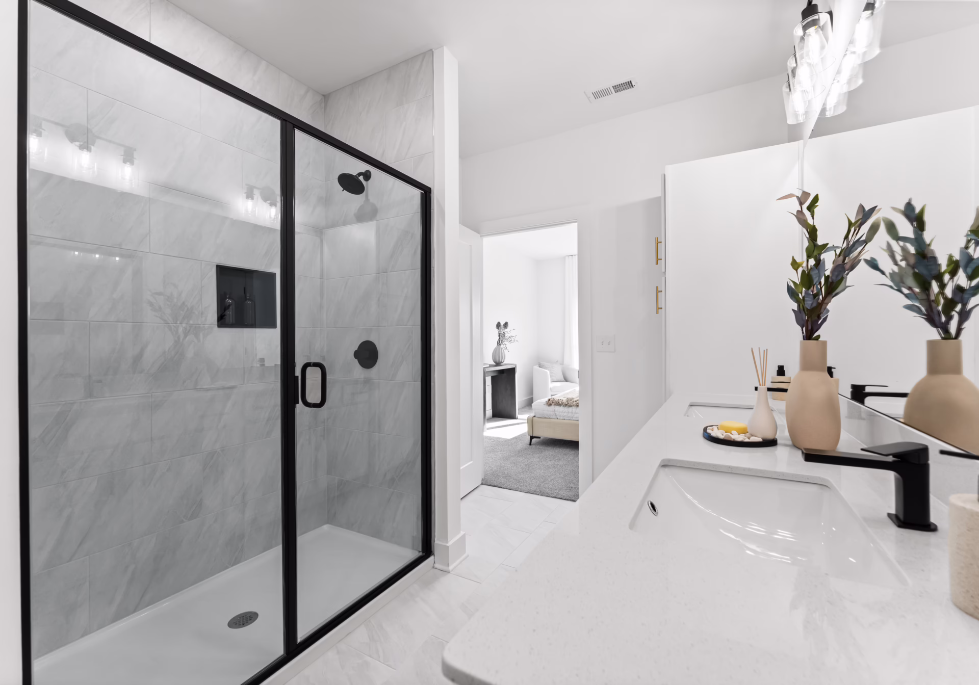 A bathroom with a large glass-enclosed shower, marble-look tile and matte-black fixtures.